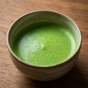 A bowl of freshly prepared pure ceremonial matcha tea featuring a smooth umami froth and bright emerald color without milk.