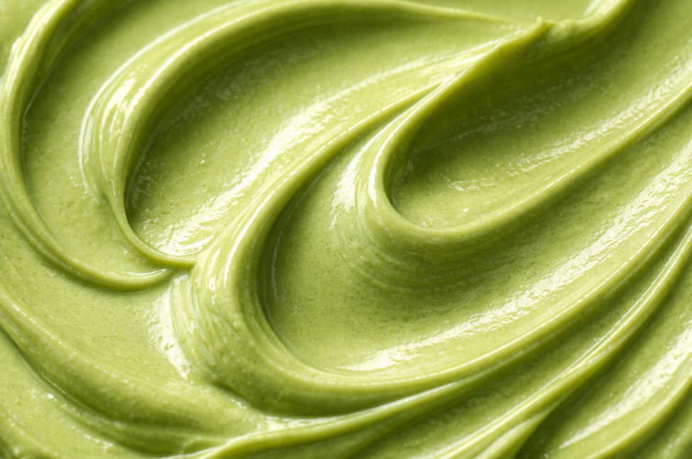 Close-up of a smooth, green cosmetic mask texture