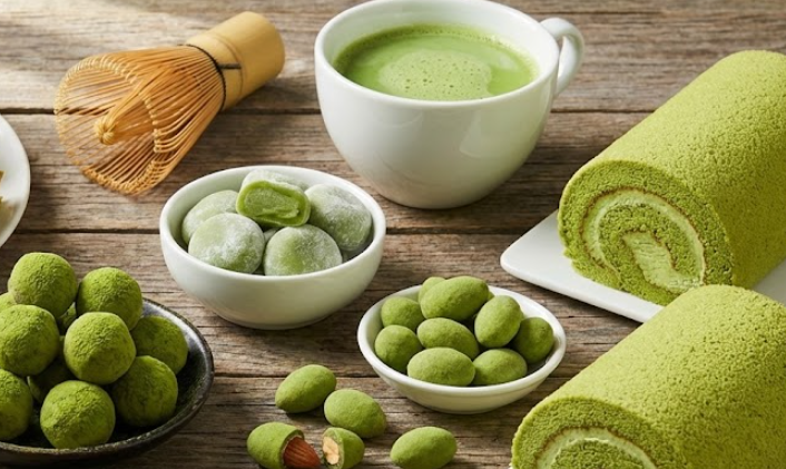 Display case of matcha pastries: croissants, mille-feuille, macarons, crepe cake.
